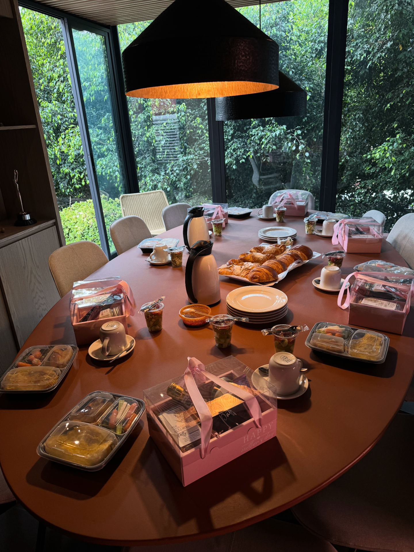 Desayuno corporativo montado en sala de juntas con panadería y box lunch