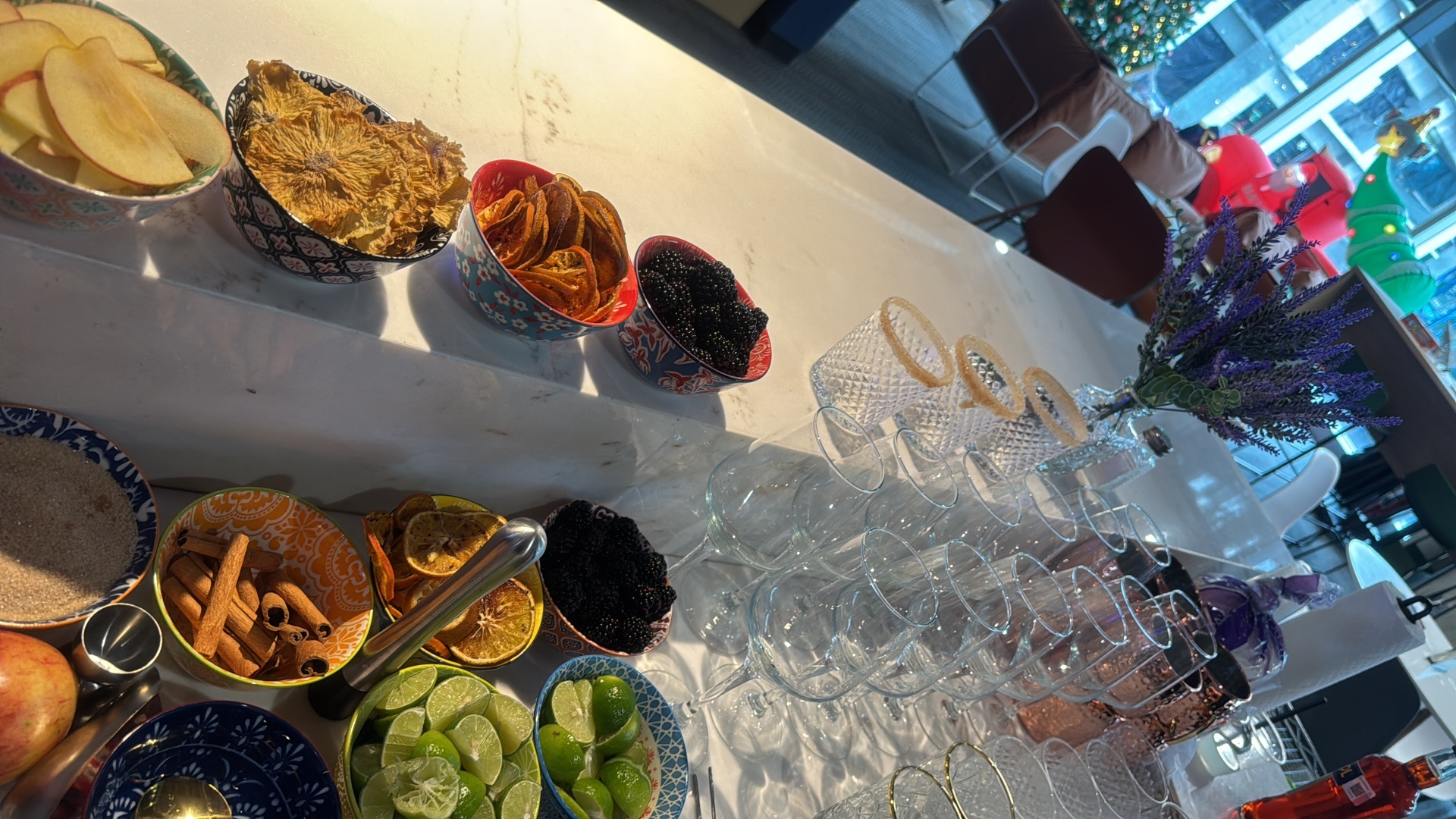 Barra de mixología con copas, frutas y especias para evento corporativo